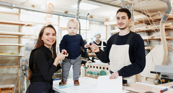 Junge Familie mit Kind in einer Werkstatt