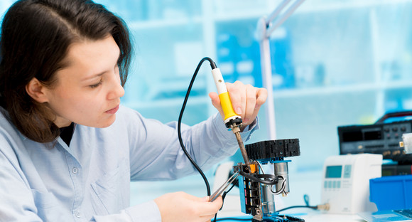 Junge Frau in einem Labor zur Entwicklung elektronischer Bauteile (Quelle: © science photo, stock.adobe.com)