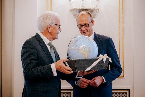 Antrittsbesuch Bundeskanzler Friedrich Merz besucht Baden-Württemberg Geschenkübergabe: Ministerpräsident Winfried Kretschmann (links) überreicht Bundeskanzler Friedrich Merz (rechts) einen Leuchtglobus