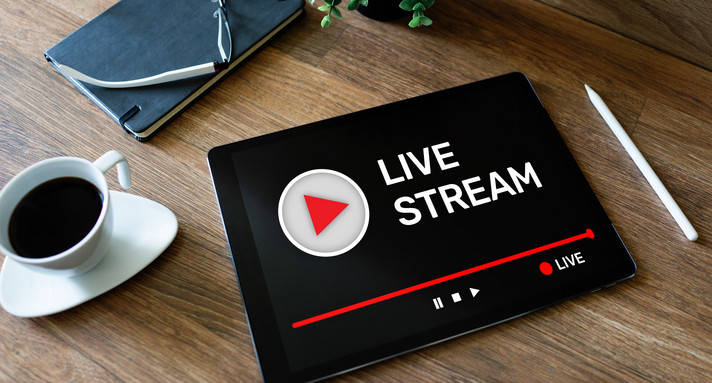 Schreibtisch mit Laptop und die Aufschrift Live-Stream