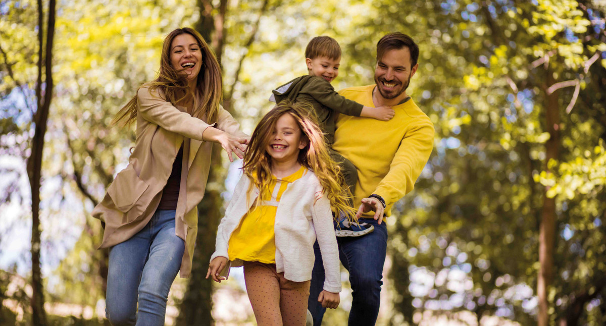 2 Kinder und 2 Erwachsene fröhlich im Wald