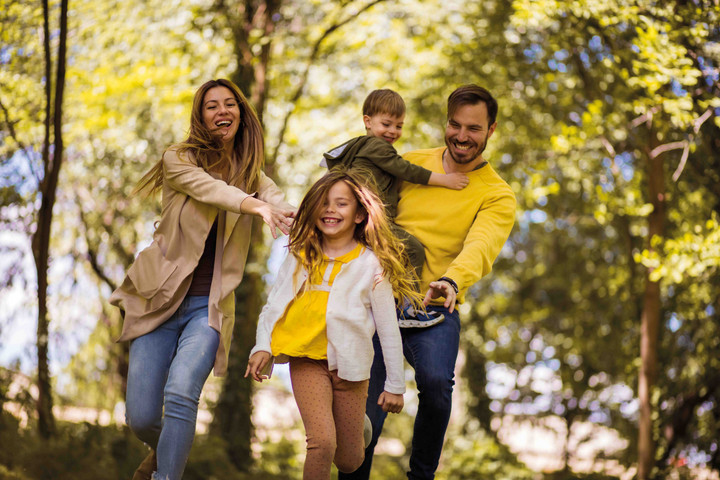 2 Kinder und 2 Erwachsene fr&ouml;hlich im Wald