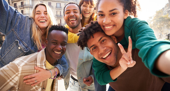 Vertical selfie of A group of cheerful students college friends travel through European cities.