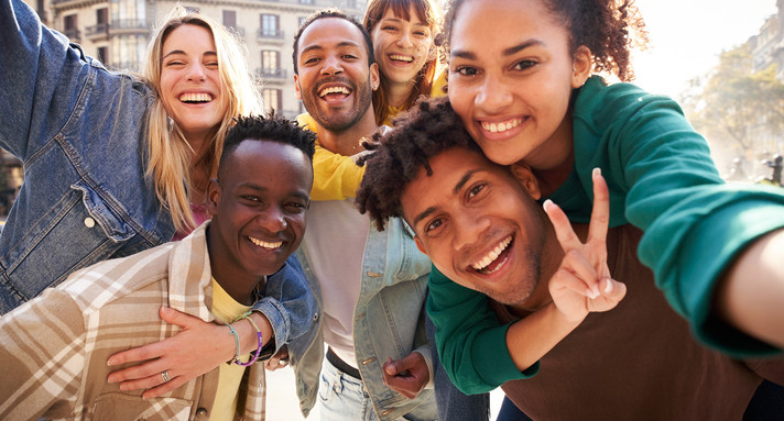 Vertical selfie of A group of cheerful students college friends travel through European cities.
