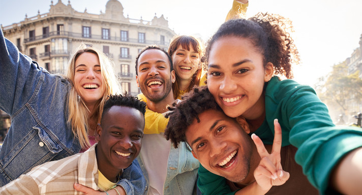 Vertical selfie of A group of cheerful students college friends travel through European cities.