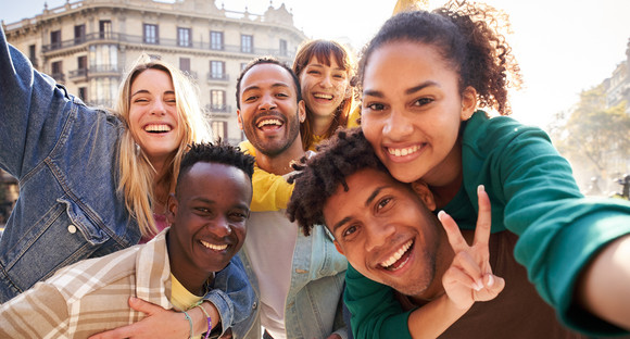 Vertical selfie of A group of cheerful students college friends travel through European cities.