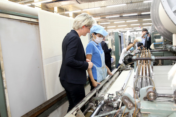 Die Ministerin an einer Maschine zur Herstellung von Garn.