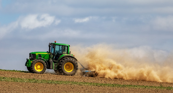 Traktor beim Eggen auf dem Feld