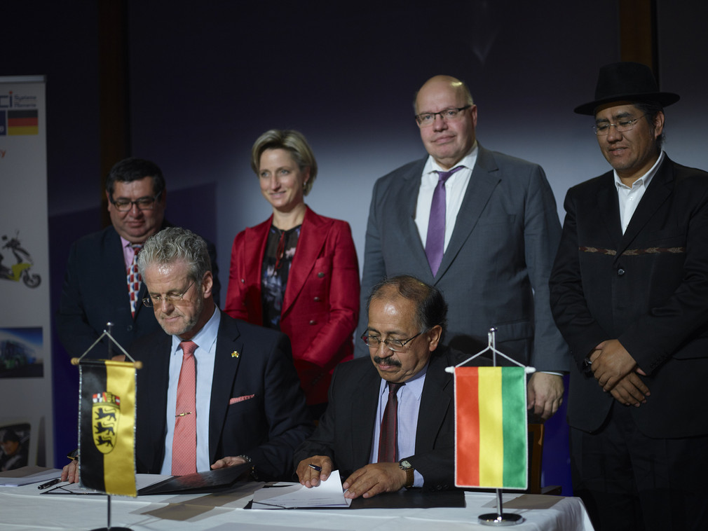 Vertrter der Unternehmen unterzeichnen den Vertrag. Im Hintergrund stehen Ministerin Hoffmeister-Kraut, Bundeswirtschaftsminister Altmaier und Vertreter der bolivianischen Regierung (Bild: © Jan Pauls)