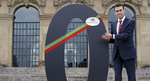 Minister Schmid mit einer symbolischen schwarzen Null