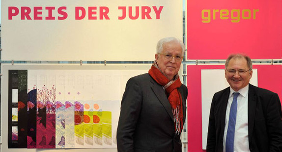 Mittelstandsbeauftragter Peter Hofelich und Friedrich Müller, Sprecher der Jury des Graphischen Klubs Stuttgart, mit dem Siegerkalender "metamorph" von Glanzmann Schöne Design Lörrach.