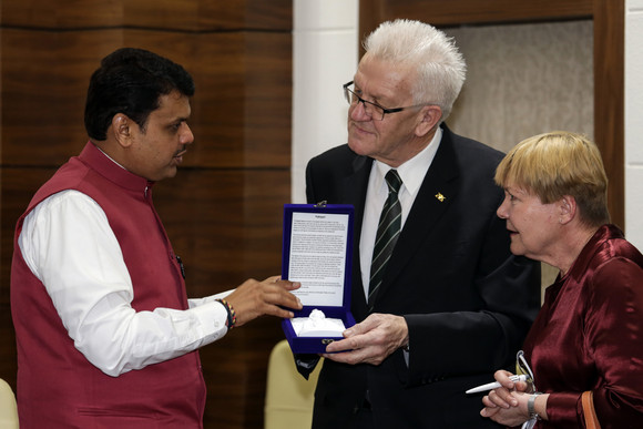 Delegationsreise Ministerpräsident Kretschmann besucht Indien Ministerpräsident Winfried Kretschmann (r.) und der Ministerpräsident von Maharashtra, Chief Minister Devendra Fadnavis (l.) bei der Übergabe eines Gastgeschenks