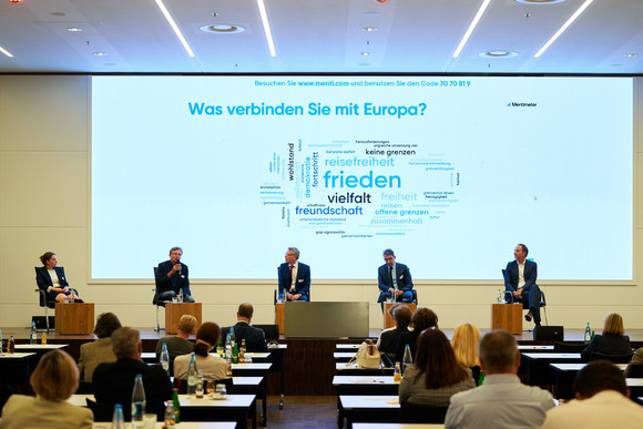 Europa Festveranstaltung „EUropa – Gestern. Heute. Morgen.“ Auf einer Bühne diskutieren die Beteiligten der Podiumsdiskussion der Festveranstaltung „EUropa – Gestern. Heute. Morgen.“