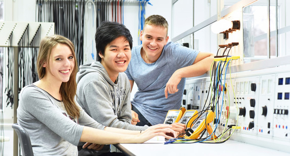 Drei Auszubildende in einer Elektronik-Werkstatt