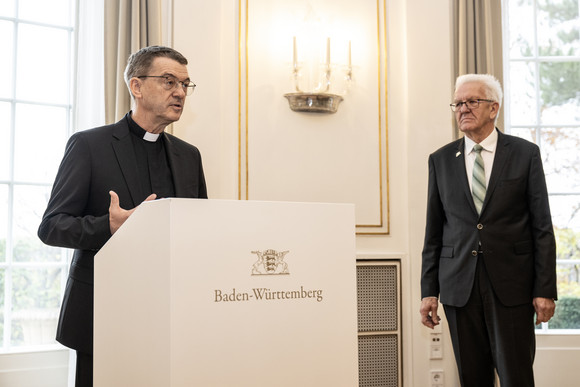 Kirche Treueversprechen des designierten Bischofs von Rottenburg-Stuttgart Der designierte Bischof von Rottenburg-Stuttgart, Prälat Dr. Klaus Krämer (links), bei seiner Ansprache, daneben steht Ministerpräsident Winfried Kretschmann (rechts).
