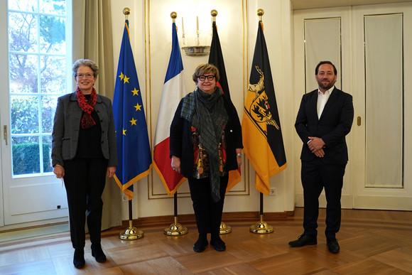 Europa Antrittsbesuch der Vizepräsidentin der Region Grand Est von links nach rechts: Staatsrätin Barbara Bosch, Brigitte Torloting, Vizepräsidentin der Region Grand Est, und Staatssekretär Florian Hassler stehen vor Fahnen.