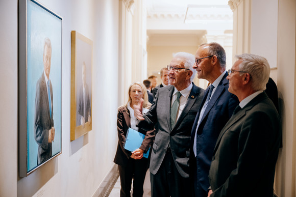 Antrittsbesuch Bundeskanzler Friedrich Merz besucht Baden-Württemberg von links nach rechts: Ministerpräsident Winfried Kretschmann, Bundeskanzler Friedrich Merz und Innenminister Thomas Strobl betrachten die Porträts der früheren Ministerpräsidenten von Baden-Württemberg