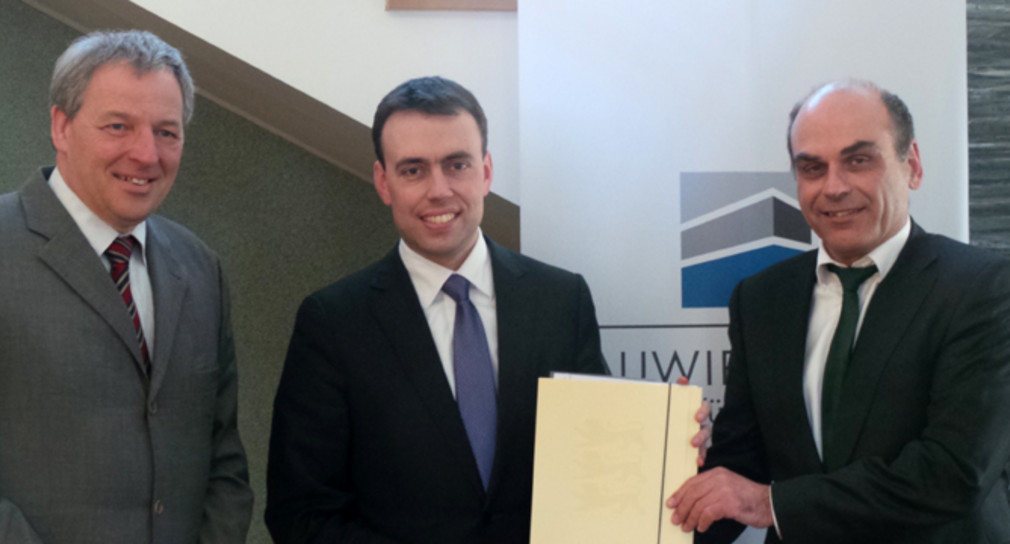 Minister Schmid übergibt einen Förderbescheid an den Hauptgeschäftsführer der Gemeinnützigen Berufsförderungsgesellschaft der Württembergischen Bauwirtschaft mbH in Stuttgart, Dieter Diener (rechts)