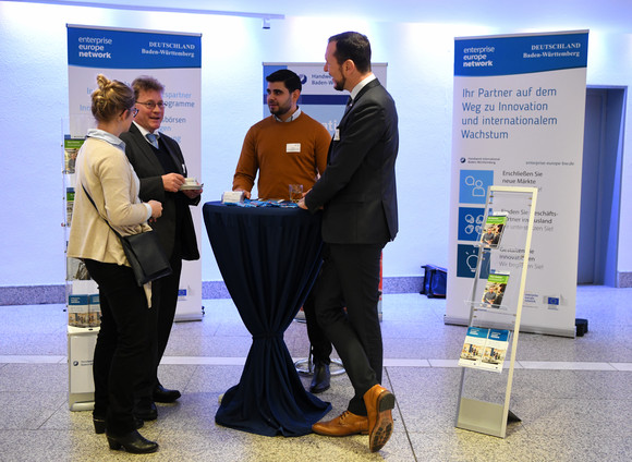 Drei Männer und eine Frau unterhalten sich vor einem Infostand auf dem Wirtschaftskongress Brexit (Quelle: Sascha Baumann / all4foto.de) 