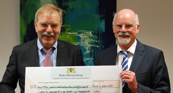 Ministerialdirektor Hubert Wicker übergibt einen Förderbescheid an den Institutsleiter des ILM, Prof. Dr. Raimund Hibst.