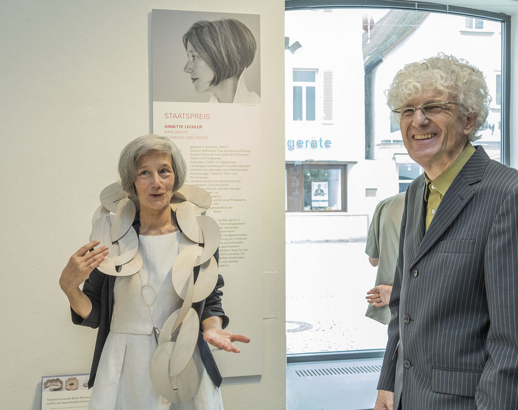 Staatspreisträgerin Annette Lechler führt ihre wandelbaren Objekte vor, rechts: Jurymitglied Joachim Haller 