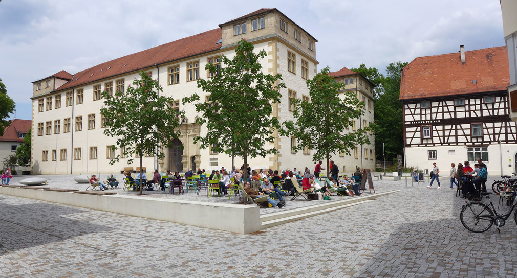 Menschen in bunten Liegestühlen genießen den Schlossplatz in Göppingen