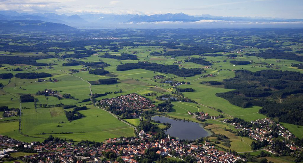 Luftaufnahme vom Allgäu: Kleine Stadt am See mit Feldern und Wiesen
