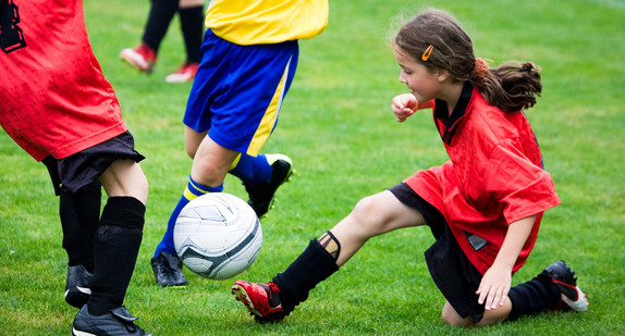 Drei Kinder beim Fußballspielen