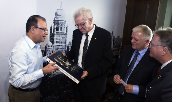 Delegationsreise Ministerpräsident Kretschmann besucht Indien Der Verwaltungsdirektor der Stadt Mumbai, Municipal Commissioner Ajoy Mehta (l.), übergibt Ministerpräsident Winfried Kretschmann (M.) ein Buch.
