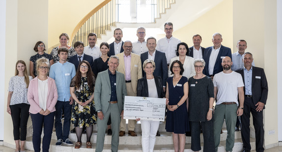 Gruppenbild mit Ministerin Dr. Hoffmeister-Kraut: Bescheidübergabe im Neuen Schloss an sechs Projektträger für Weiterbildungsprojekte im Bereich nachaltiges Bauen.