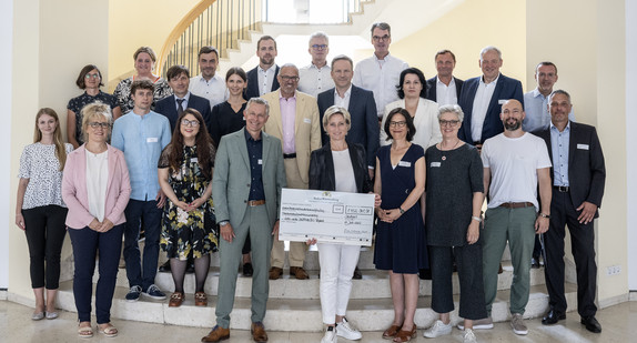 Gruppenbild mit Ministerin Dr. Hoffmeister-Kraut: Bescheidübergabe im Neuen Schloss an sechs Projektträger für Weiterbildungsprojekte im Bereich nachaltiges Bauen.