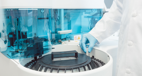 Labortechniker best&uuml;ckt Zentrifuge mit Blutr&ouml;hrchen