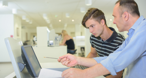 Auszubildender und Meister vor einem Monitor (Quelle: auremar, stock.adobe.com)