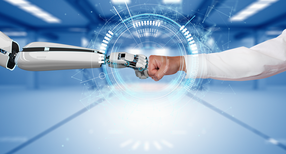 Roboter und Mensch begr&uuml;&szlig;en sich, in dem Sie die Faustkn&ouml;chel gegeneinanderdr&uuml;cken