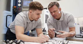 Auszubildender und Lehrer an einer CAD-Maschine (Quelle: &copy; Monkey Business, stock.adobe.com)