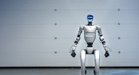 humanoider Roboter stehend in einem grauen Raum