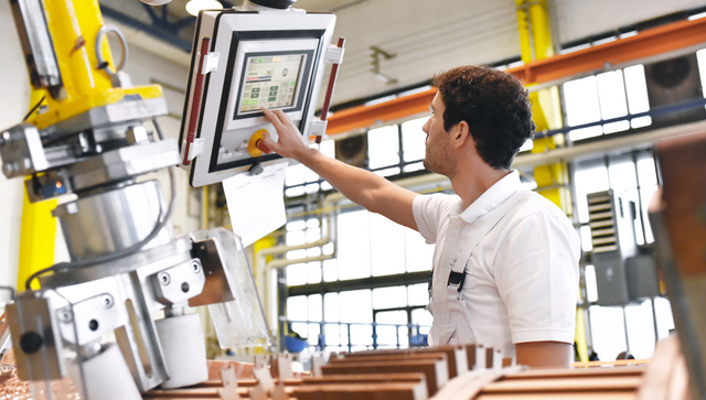 Junger Maschinenbauer steuert eine Maschine &uuml;ber einen Monitor (Bild: &copy; industrieblick, stock.adobe)