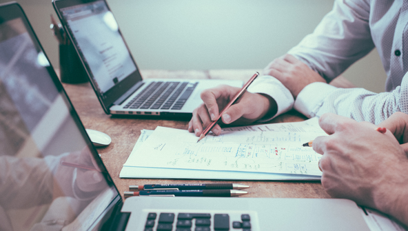 Zwei Personen arbeiten an ihren Laptops und skizzieren ein Gesch&auml;ftsmodell